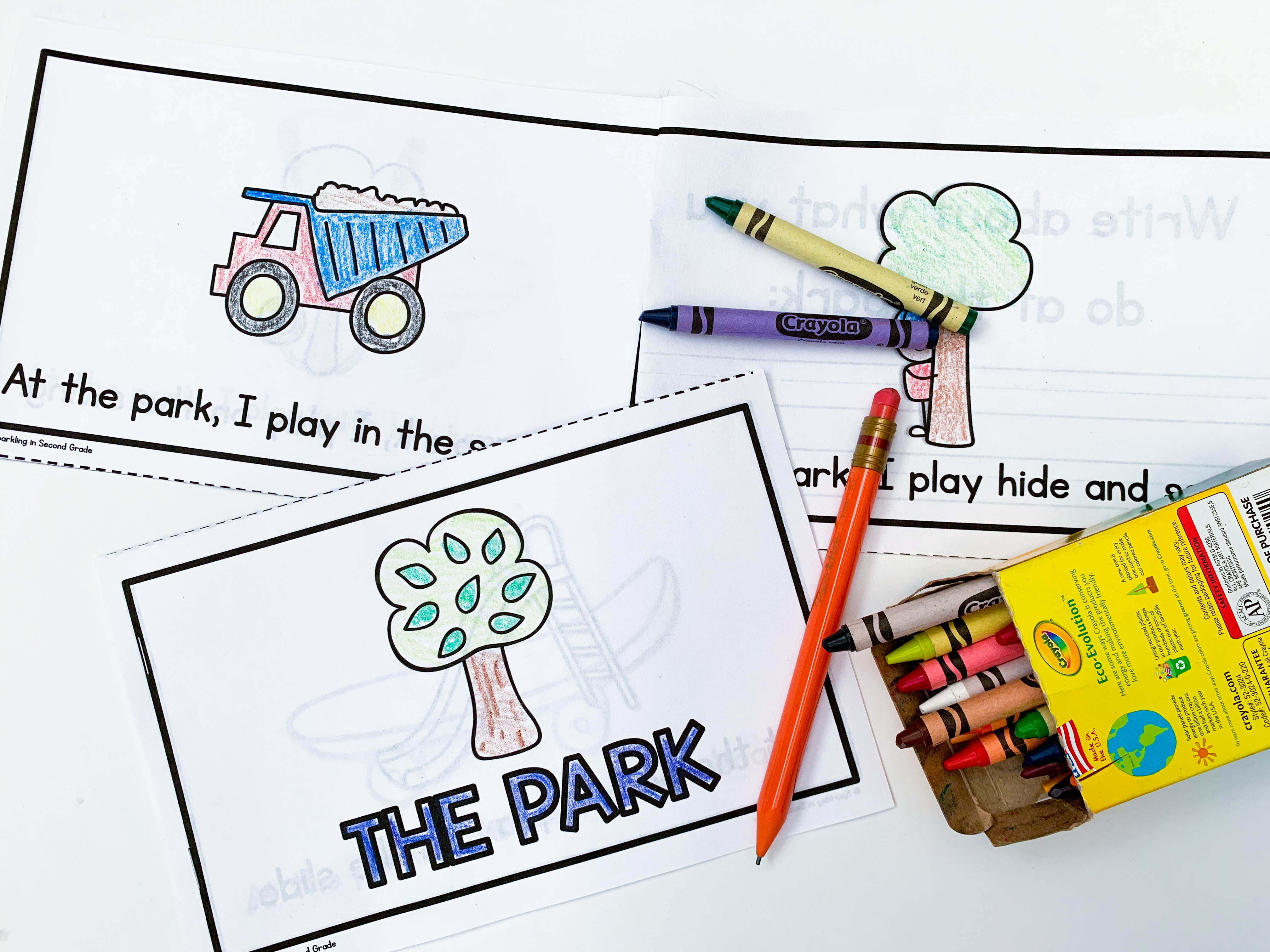 A picture of an emergent reader with crayons and a pencil.